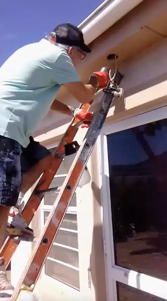 Charles removing a beehive from a home wall